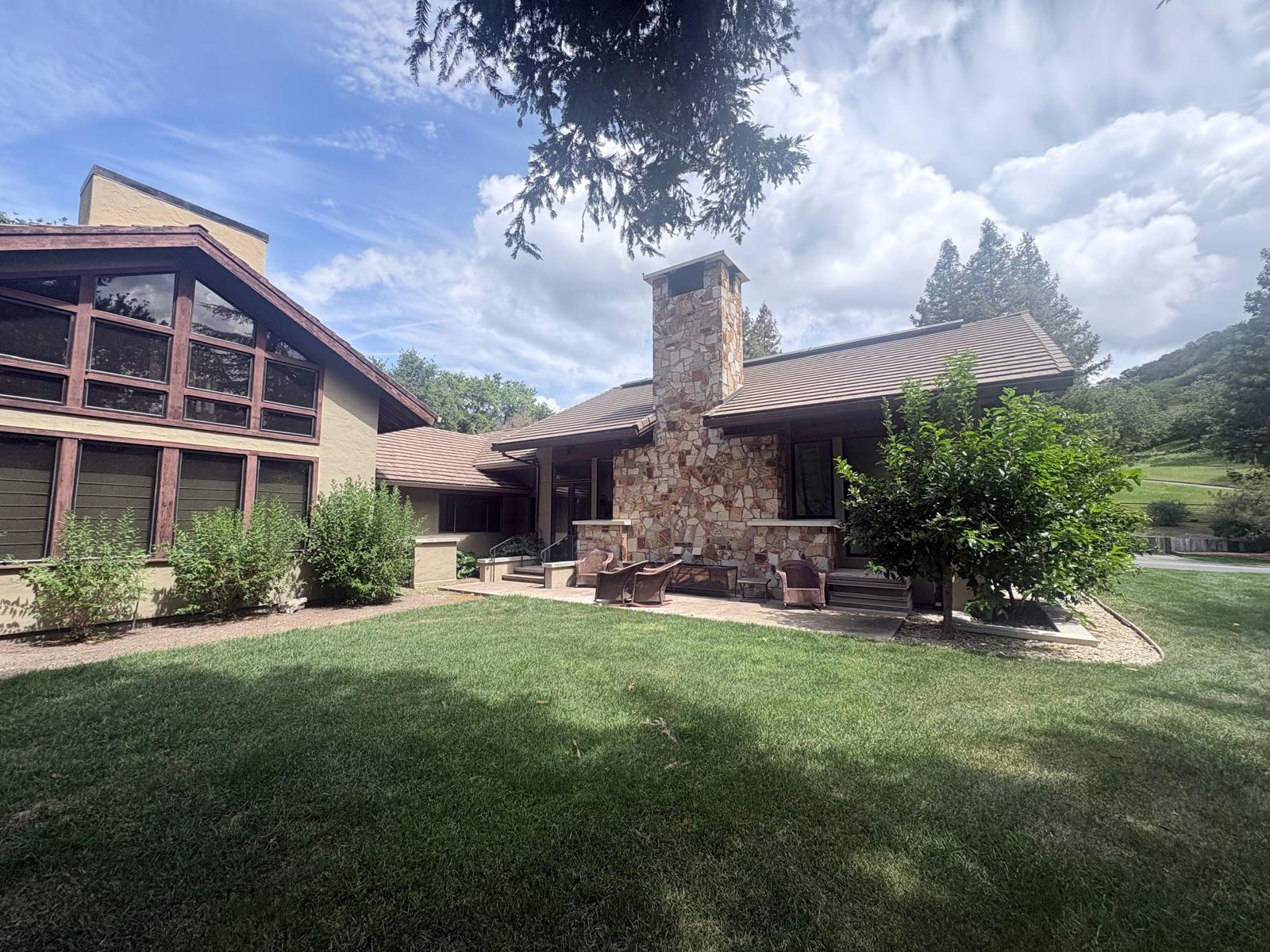 Entry of a home with stucco walls, stone-textured columns, and a red front door